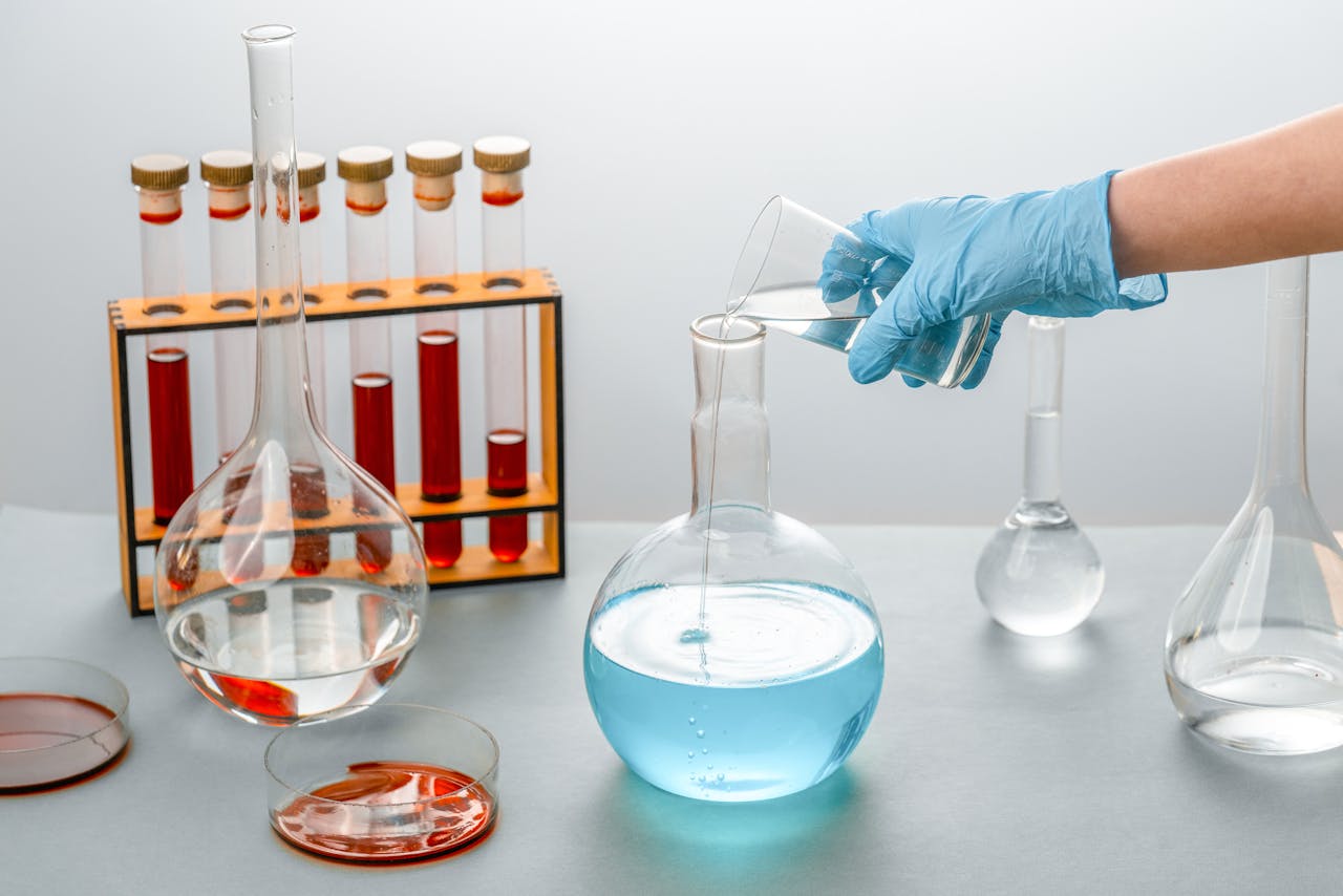 Close-up of scientist pouring liquid into a flask in a laboratory setting