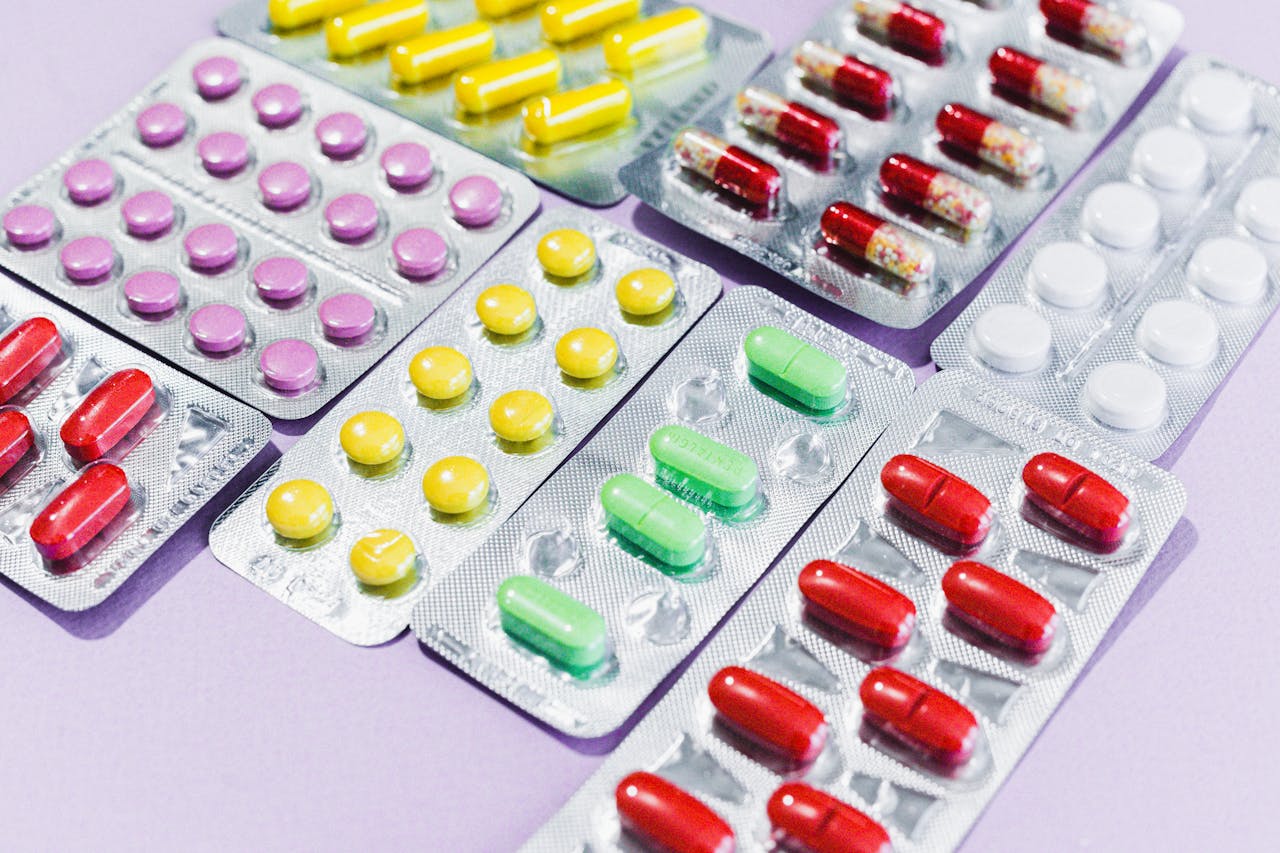 Close-up of various colorful pills in blister packs, showcasing diverse medicine types.
